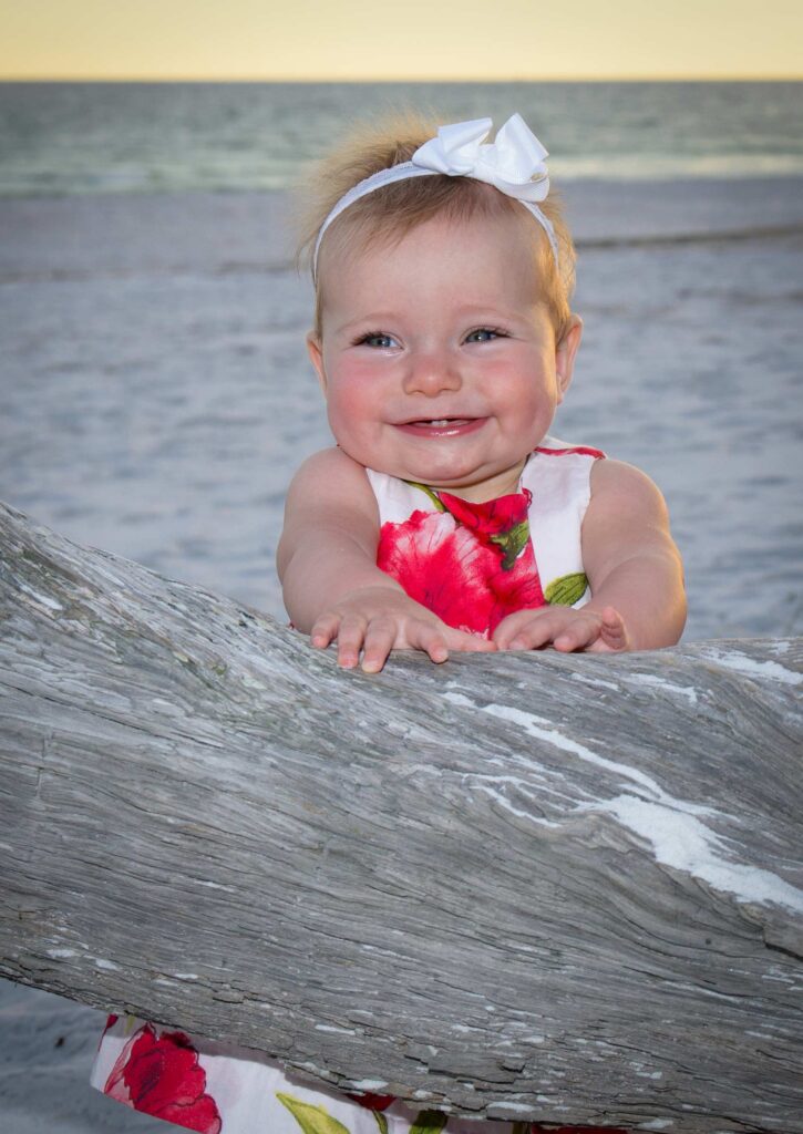 Smiling baby girl on the beach captured by our Destin baby photographer.