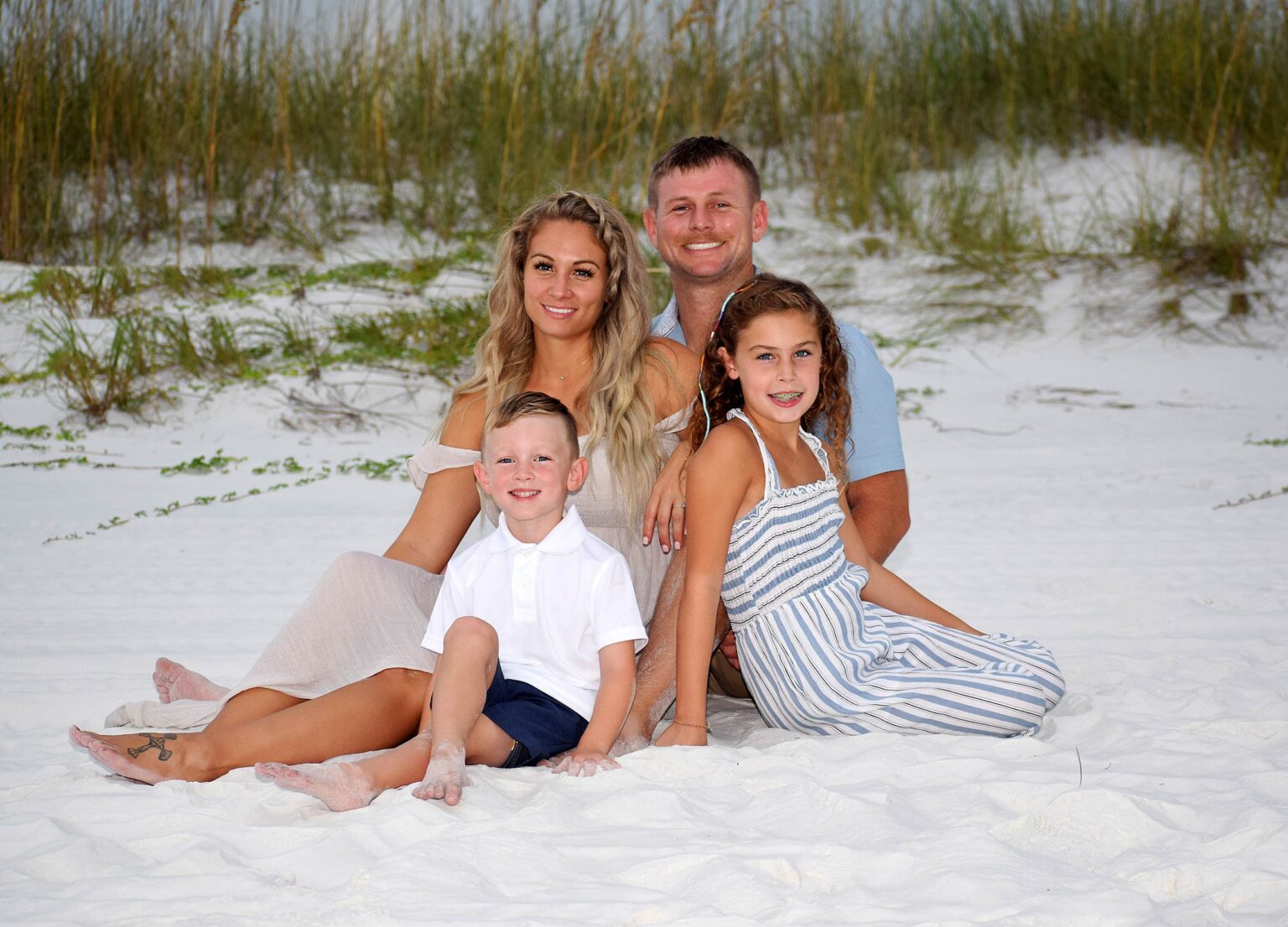 Family of 4 sitting in the sand