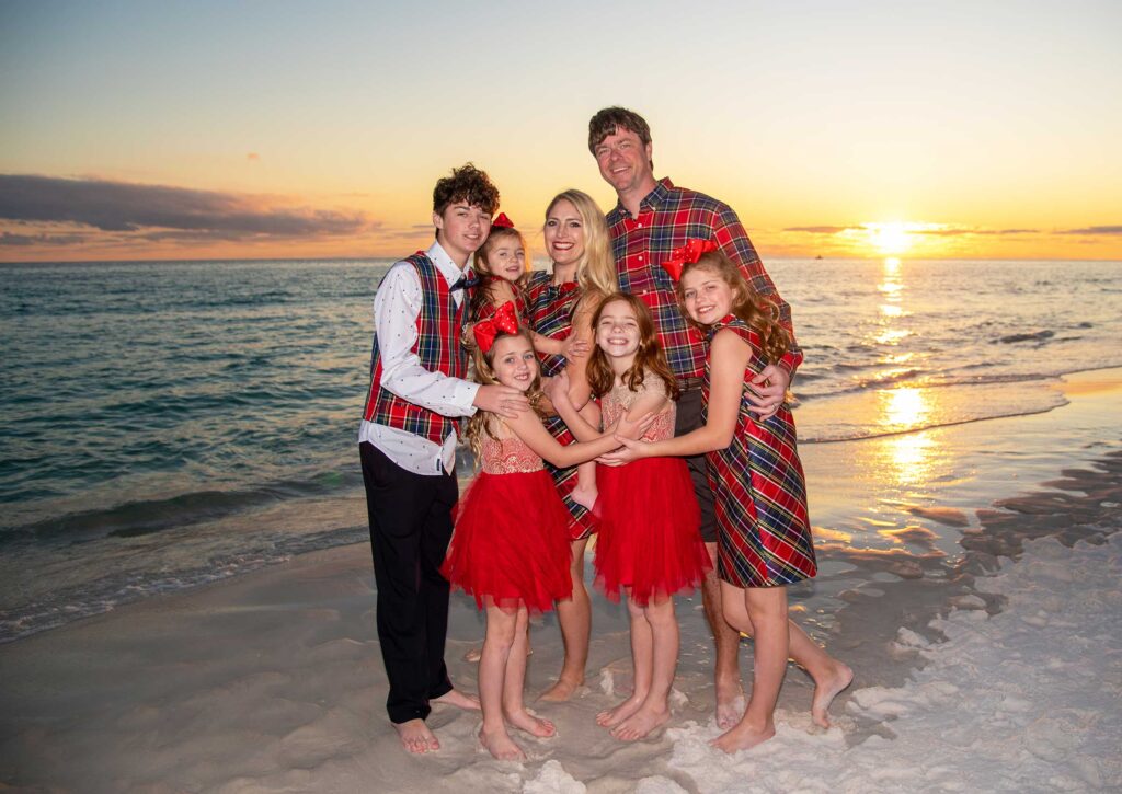 Family getting their Destin holiday photo taken at sunset