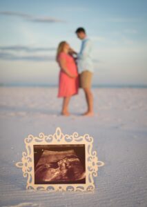 Maternity photo on the beach in Destin with sonogram in the foreground