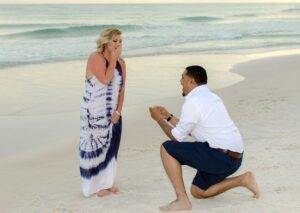 Man on one knee at beach proposing