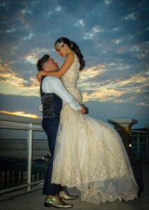 Bride and groom embracing in front of beautiful sunset