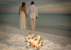 wedding bouquet with wedding couple in the background