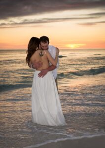 Couple hugging on Destin beach at sunset.