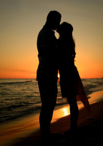 Silhouette photo at sunset - couple kissing on Destin Beach in Florida