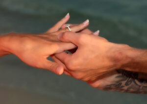 Man putting ring on woman's finger