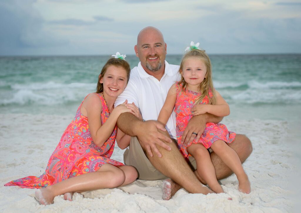 Sitting on sand for a family picture.