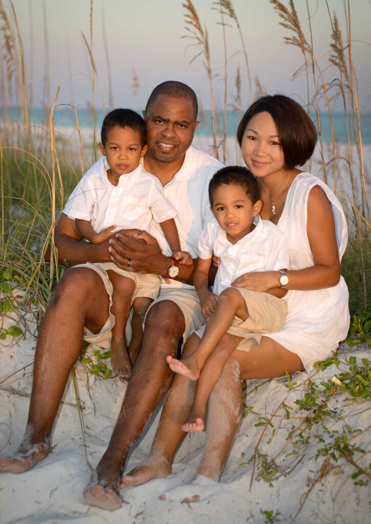 Family posing near sea oats for beach pictures.