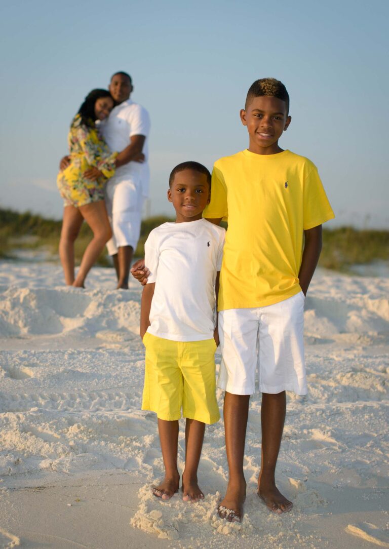 Brothers smile for the camera while mom and dad look on from behind.