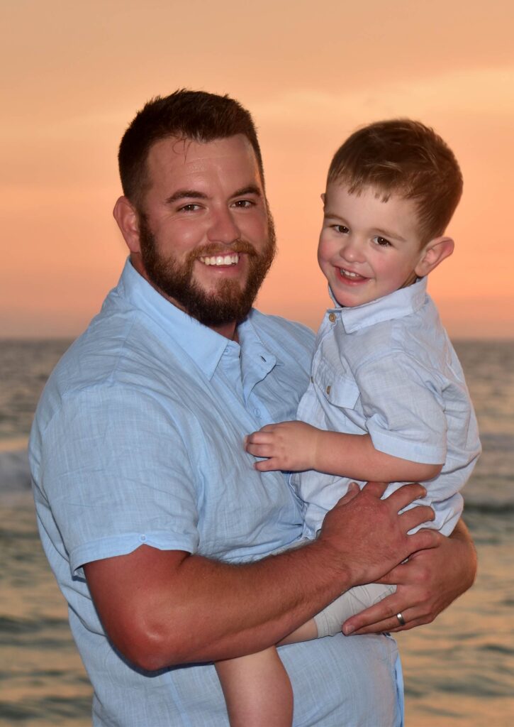 Dad and son on the beach at sunset