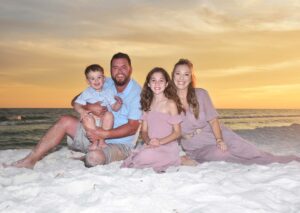 Family on the beach at sunset by our one of our beach sunset photographers